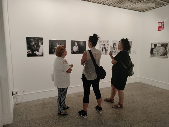 Tres mujeres contemplan la exposición Tinta y luz sobre violencia machista